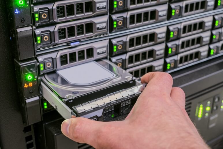 Ein IT-Techniker setzt eine Festplatte in ein Serverrack ein.